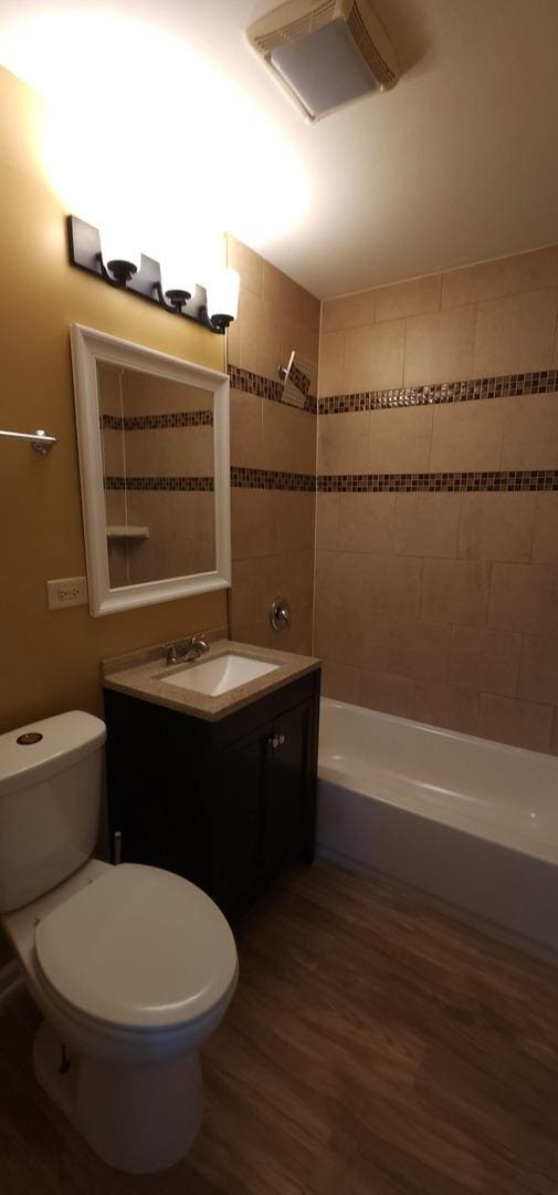 bathroom with toilet, vanity, and wood-type flooring