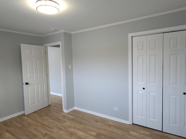 unfurnished bedroom featuring a closet, ornamental molding, and light hardwood / wood-style flooring