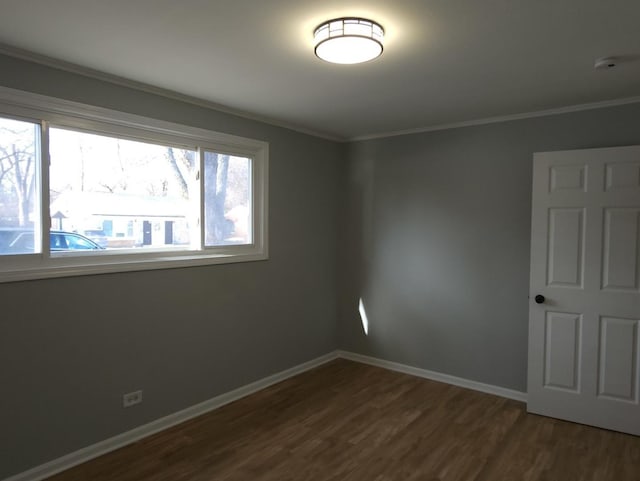 spare room featuring dark wood-type flooring and ornamental molding