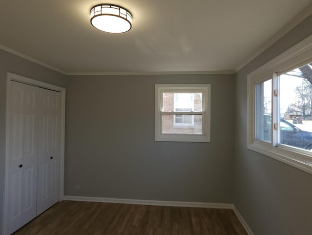 unfurnished bedroom featuring a closet, dark hardwood / wood-style floors, crown molding, and multiple windows