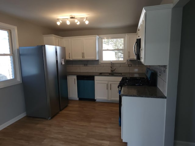 kitchen featuring dark hardwood / wood-style floors, decorative backsplash, sink, white cabinetry, and appliances with stainless steel finishes