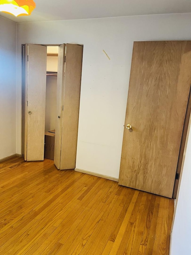 unfurnished bedroom featuring light hardwood / wood-style floors and a closet