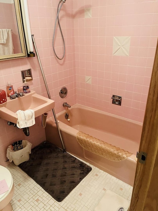 full bathroom featuring tiled shower / bath combo, sink, tile walls, and backsplash