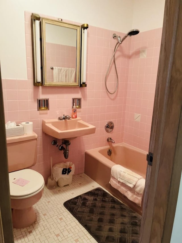 full bathroom featuring toilet, sink, tiled shower / bath, tile walls, and tile patterned flooring