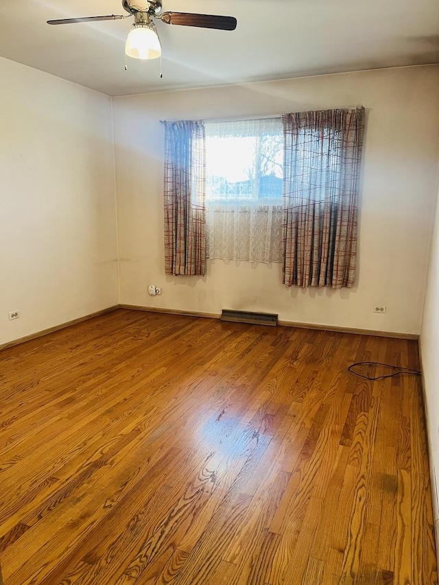 empty room featuring hardwood / wood-style floors and ceiling fan