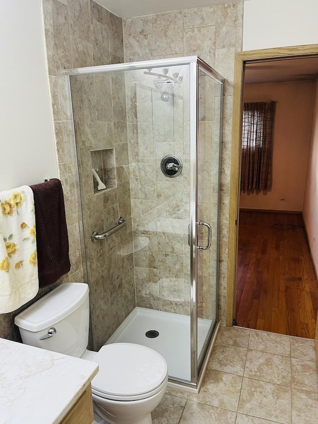 bathroom with walk in shower, tile patterned floors, vanity, and toilet