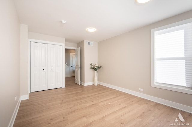 unfurnished bedroom featuring a closet and light wood-type flooring