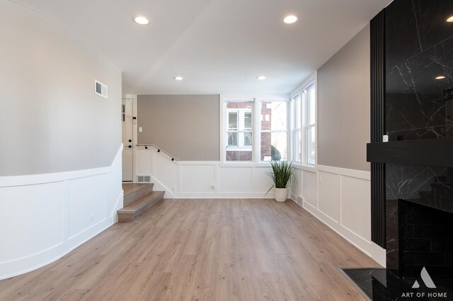 interior space featuring light hardwood / wood-style floors and a high end fireplace