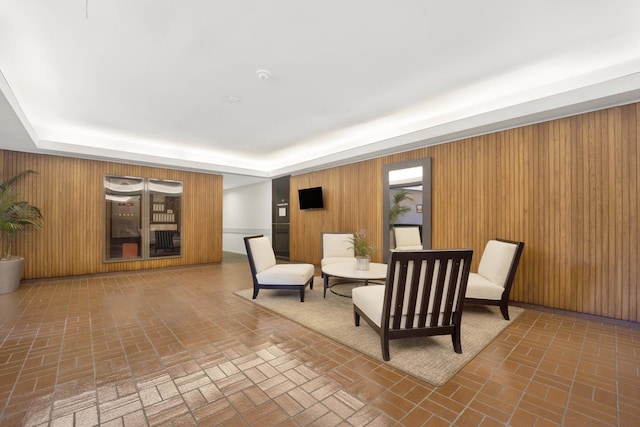 sitting room featuring wooden walls