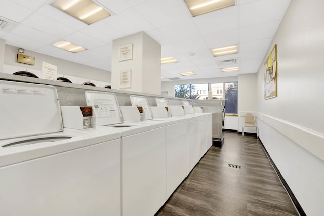 clothes washing area with dark hardwood / wood-style flooring and independent washer and dryer