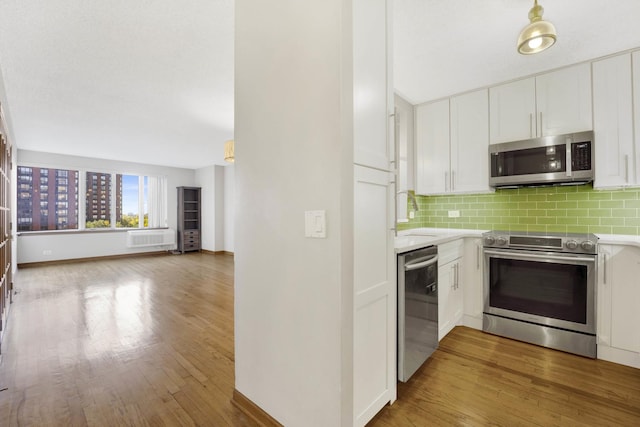 kitchen with backsplash, hardwood / wood-style floors, sink, stainless steel appliances, and white cabinets