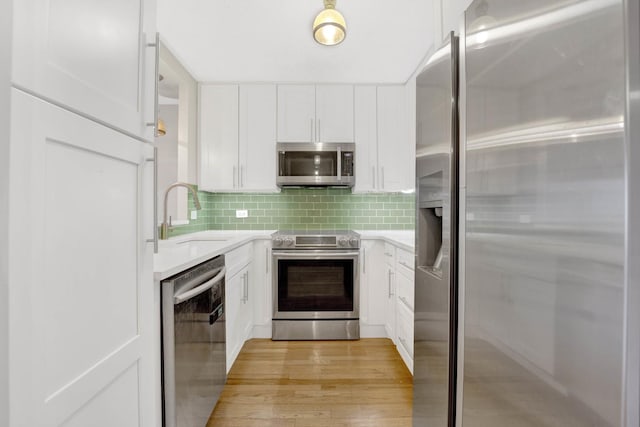 kitchen featuring tasteful backsplash, light hardwood / wood-style floors, sink, appliances with stainless steel finishes, and white cabinets