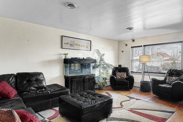 living room featuring a baseboard heating unit and hardwood / wood-style floors