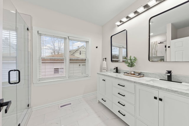 bathroom featuring a shower with shower door and vanity