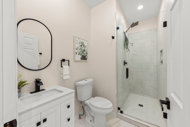 bathroom with toilet, vanity, and a shower with door