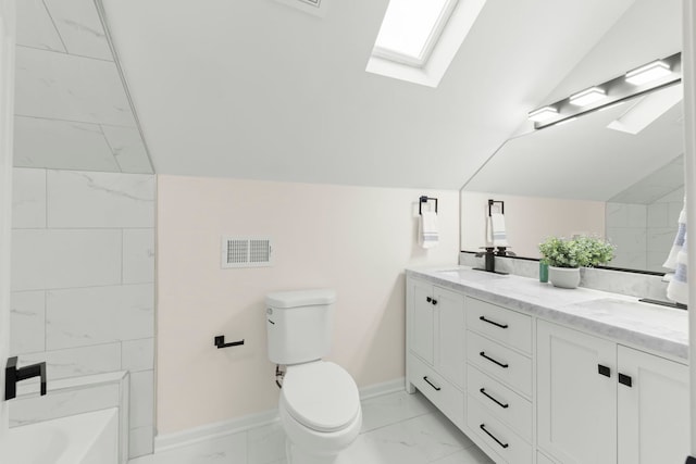 bathroom featuring toilet, vaulted ceiling with skylight, a tub, and vanity