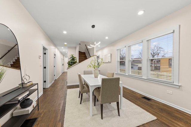 dining room with dark hardwood / wood-style flooring and a chandelier