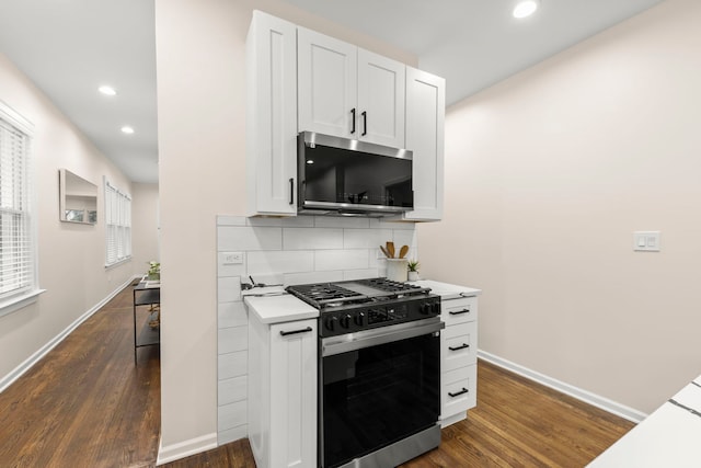 kitchen with tasteful backsplash, white cabinets, dark hardwood / wood-style floors, and stainless steel appliances