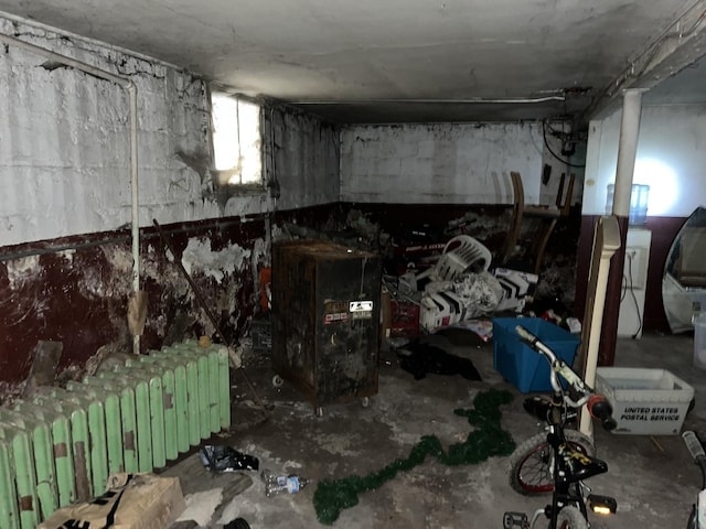 miscellaneous room featuring radiator heating unit and concrete flooring