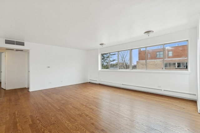 empty room featuring light hardwood / wood-style flooring and a baseboard radiator