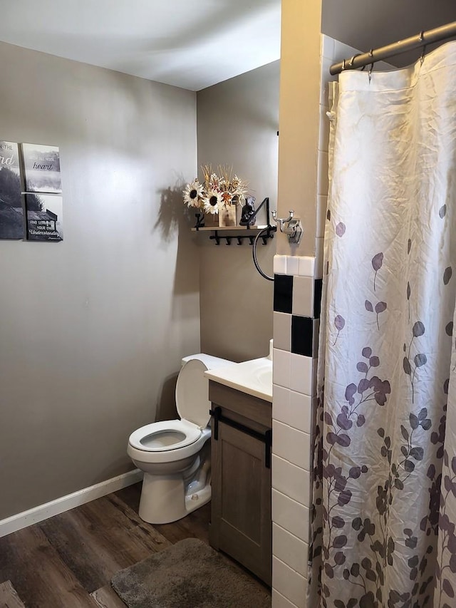 bathroom with walk in shower, vanity, toilet, and hardwood / wood-style floors