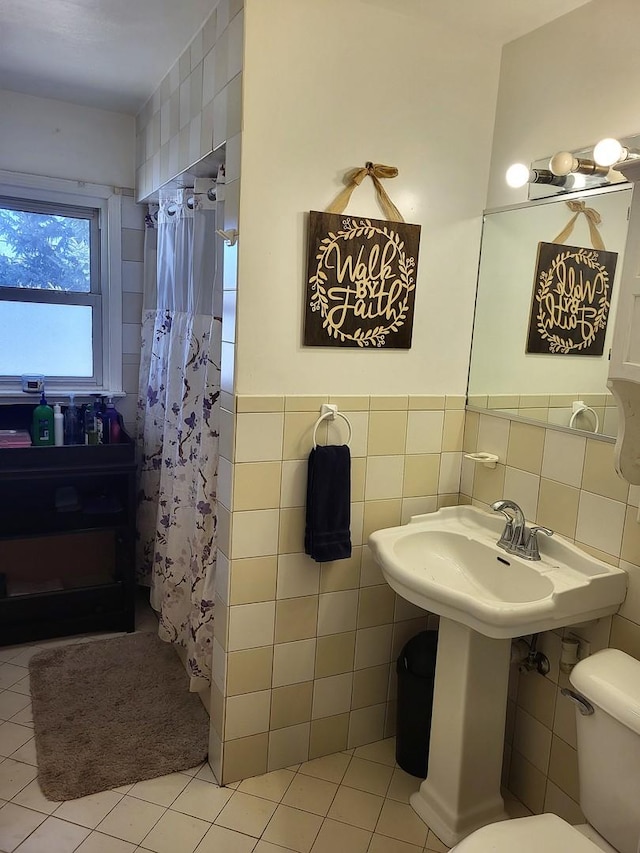 bathroom with tile walls, tile patterned floors, toilet, and walk in shower