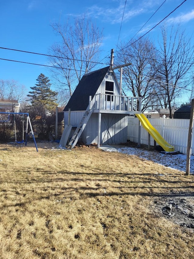 back of house with a playground and a lawn