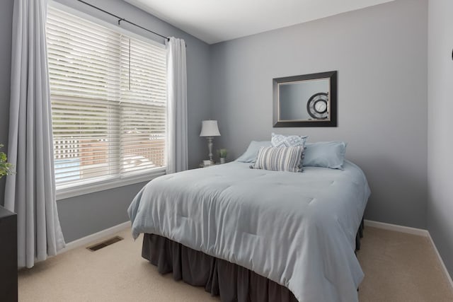 carpeted bedroom featuring multiple windows