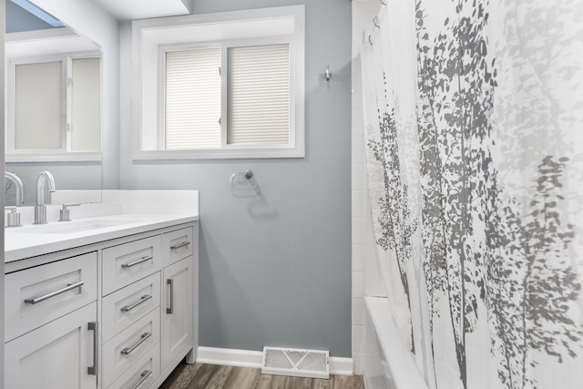 bathroom with vanity, hardwood / wood-style flooring, and shower / bath combo