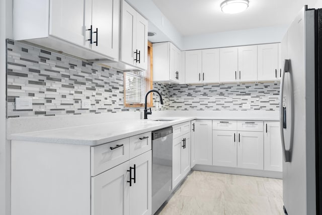 kitchen with white cabinetry, stainless steel appliances, sink, and backsplash