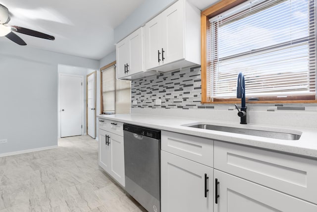 kitchen featuring tasteful backsplash, white cabinetry, sink, and stainless steel dishwasher