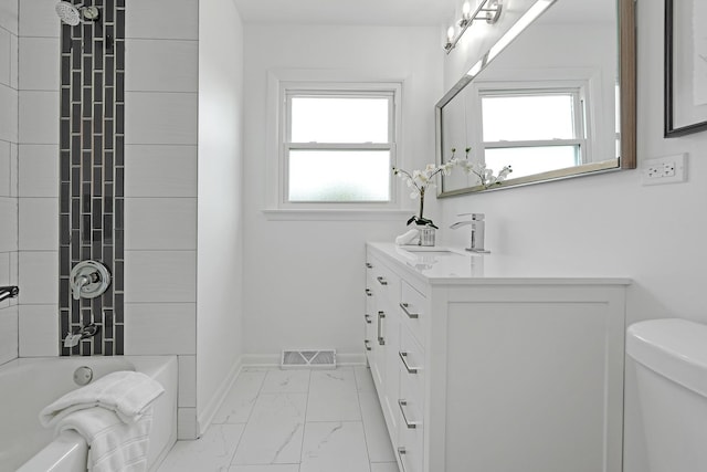 full bathroom featuring toilet, tiled shower / bath, and vanity