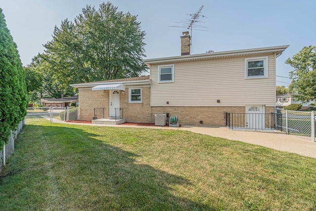 back of property featuring central AC unit and a lawn