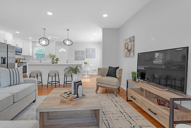 living room featuring light hardwood / wood-style floors and sink