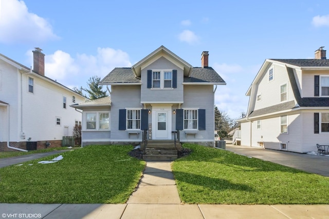 view of front of property with central AC, a front yard, roof with shingles, and a chimney