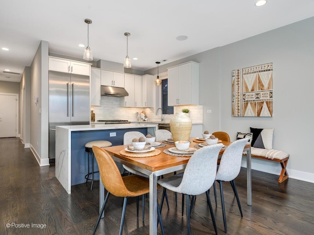 dining space with dark wood-type flooring and sink