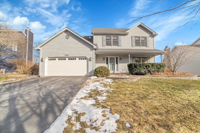 front of property featuring a front lawn, a garage, and a porch