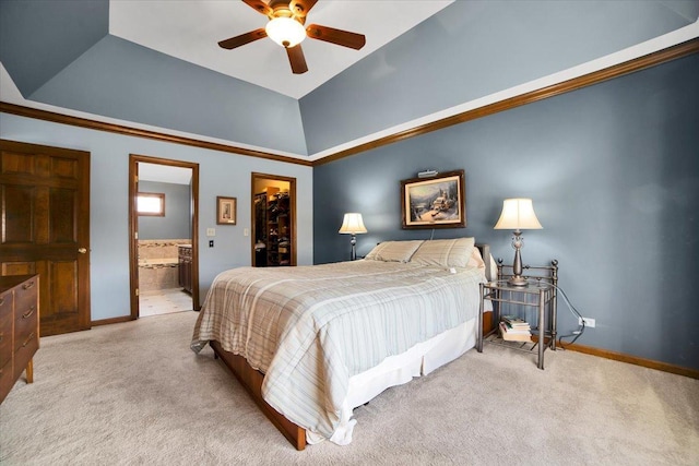 carpeted bedroom with ceiling fan, ensuite bath, a raised ceiling, a spacious closet, and a closet