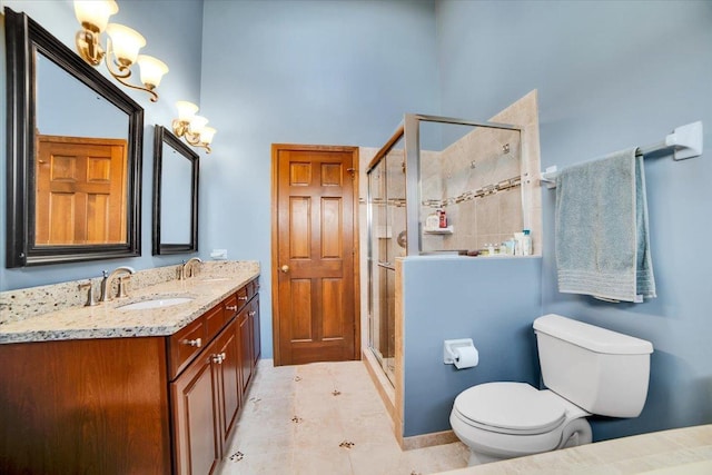 bathroom with a shower with shower door, tile patterned floors, vanity, and toilet