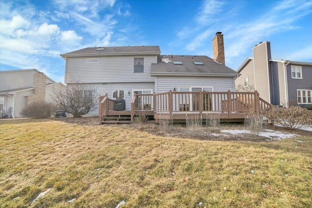 rear view of house featuring a deck and a yard