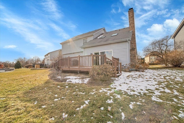 rear view of house with a deck and a yard