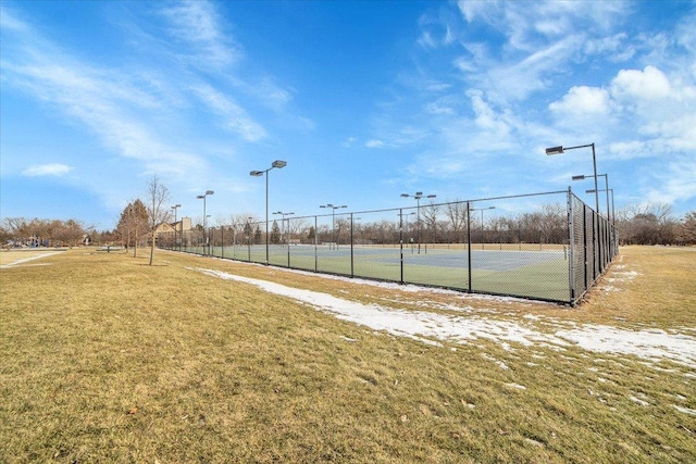 view of community with tennis court and a yard