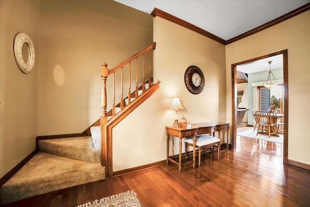 stairs featuring a chandelier, crown molding, and wood-type flooring