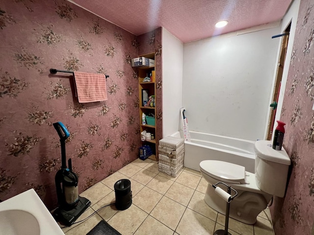 bathroom with a bathtub, tile patterned floors, a textured ceiling, and toilet