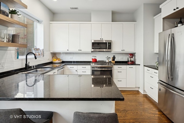 kitchen featuring white cabinetry, sink, backsplash, and appliances with stainless steel finishes