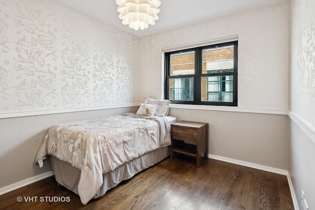 bedroom with dark wood-type flooring and a chandelier