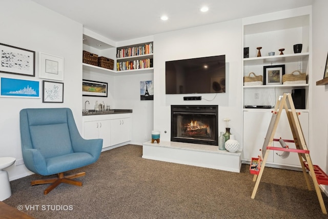 living area featuring built in features and dark colored carpet