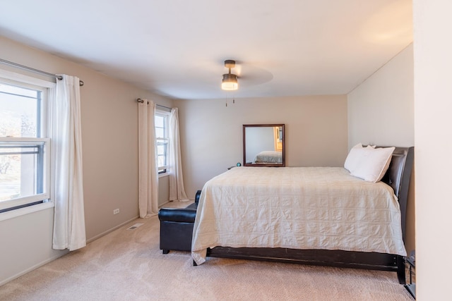 carpeted bedroom with ceiling fan and multiple windows