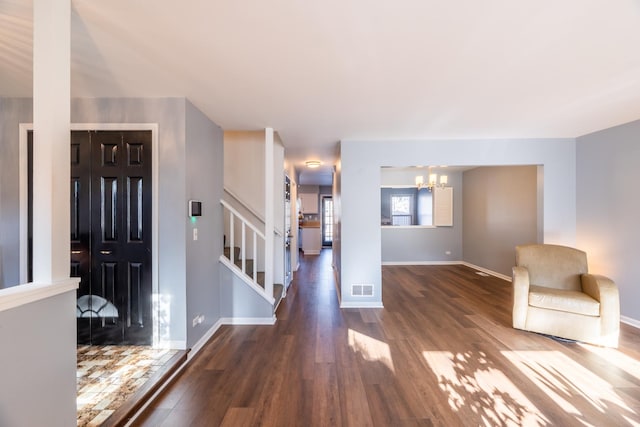 entrance foyer featuring dark hardwood / wood-style flooring and an inviting chandelier