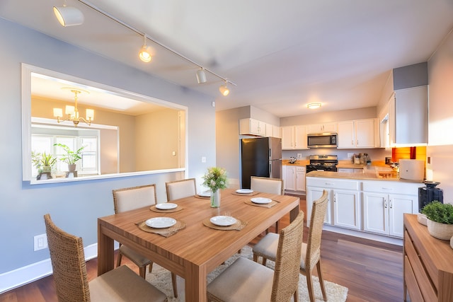 dining room with dark hardwood / wood-style floors and a chandelier